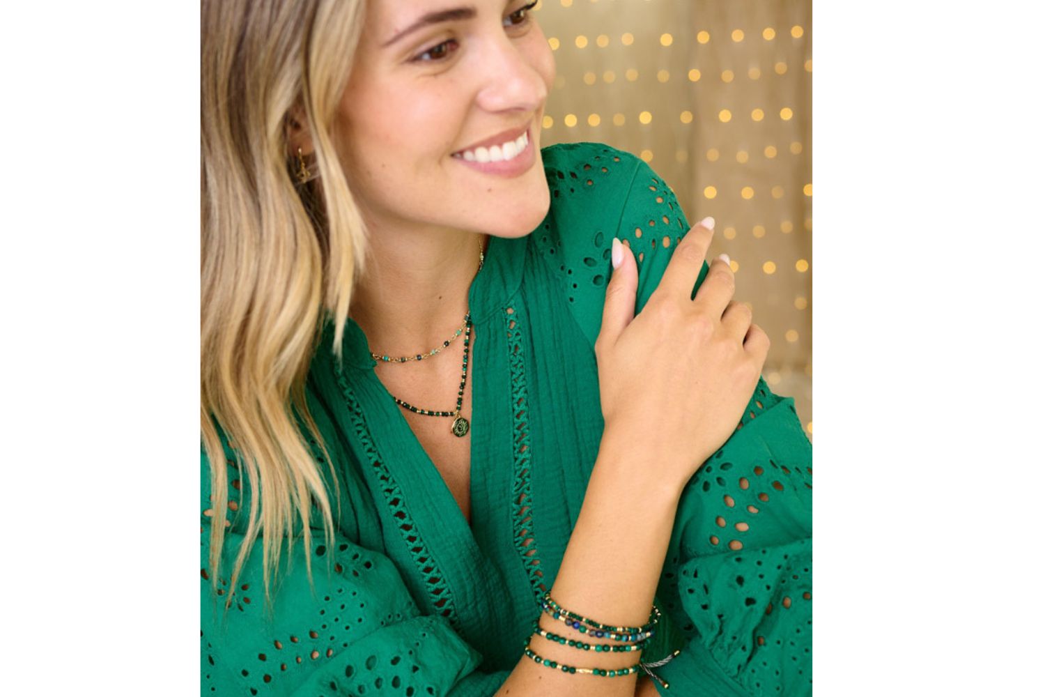 Lifestyle picture showing the Dash Malachite stretch bracelet as part of a set with the Darlene Malachite necklace. The model is layering with a panacea azurite necklace and other malachite stacking bracelets 