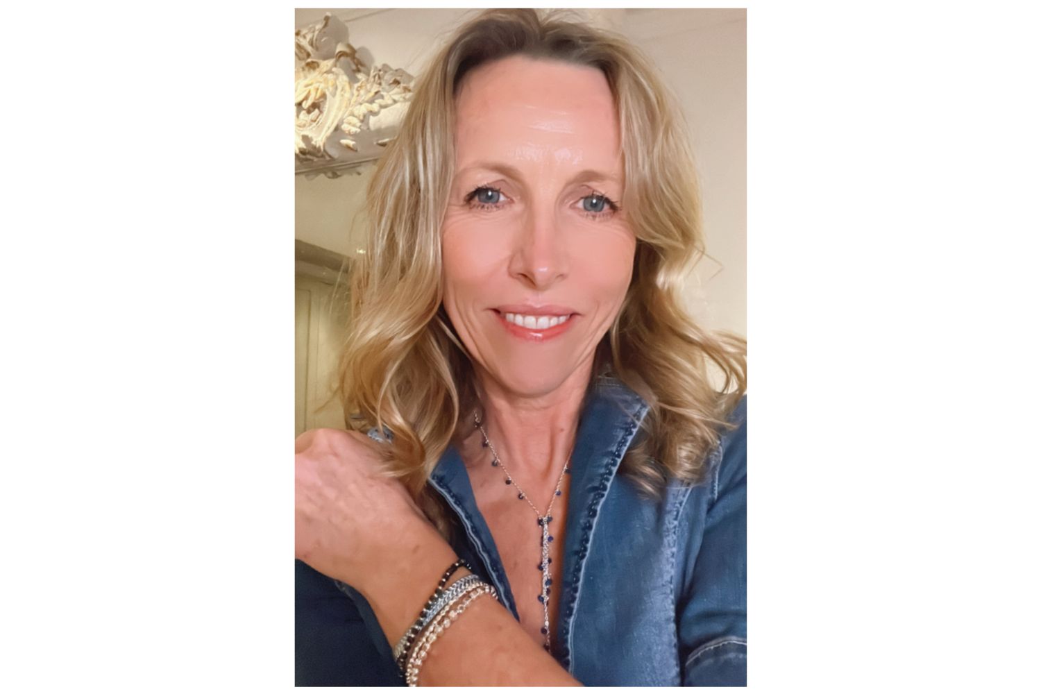 Lifestyle picture showcasing the Ivy kyanite silver lariat gemstone necklace by Betty herself. A lifestyle picture showing a denim jumpsuit and accssorised with Boho Betty braided bracelet and layering stretchy bracelets, effortless styling.