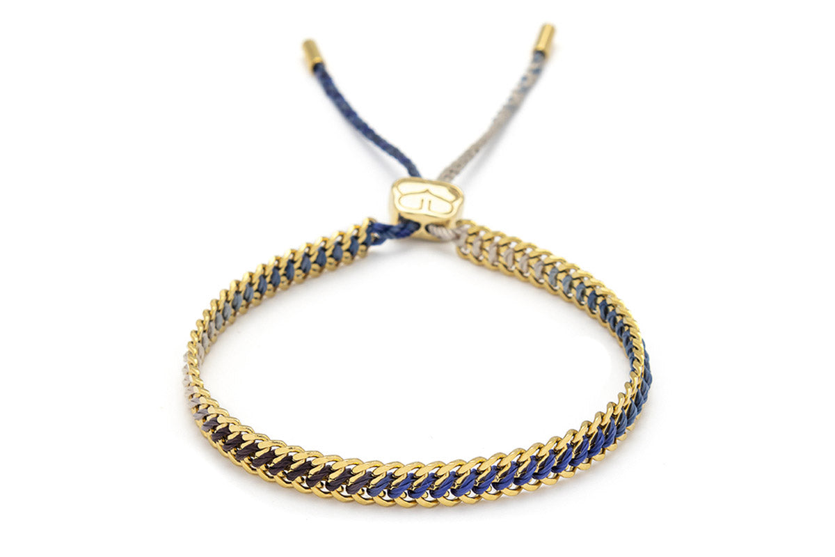 Athena Denim Gold Braided Bracelet with blue ombre thread and 14k PVD gold-plated curb chain, perfect for adding a touch of beachy boho style to your everyday look.