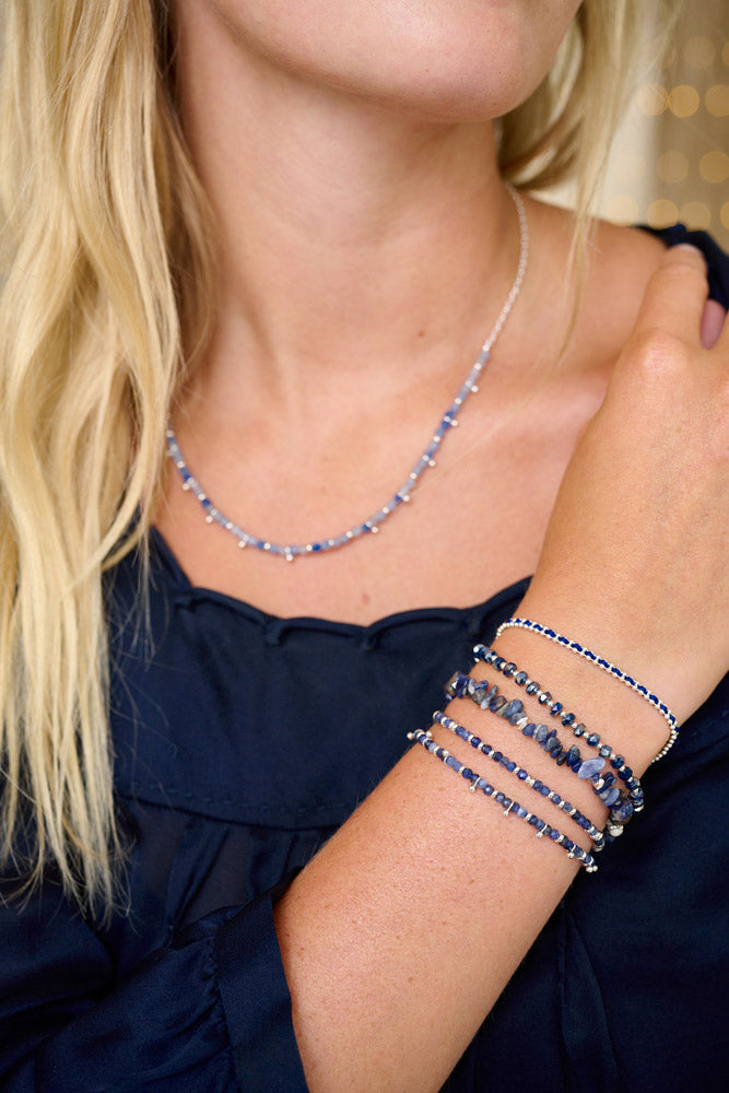 Kadavu Denim Sodalite & Silver Bracelet Stack styled on the wrist, showcasing deep blue Sodalite gemstones, silver accents, and a navy braided cord for a relaxed, boho-chic style, making this the perfect winter layering stack.