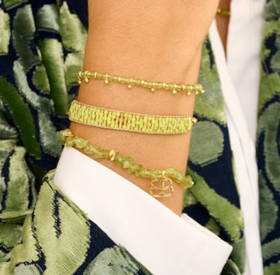 Koro Peridot Gold Bracelet Stack styled on the wrist, showcasing green peridot beads and shimmering gold details for a chic, summer-ready look.