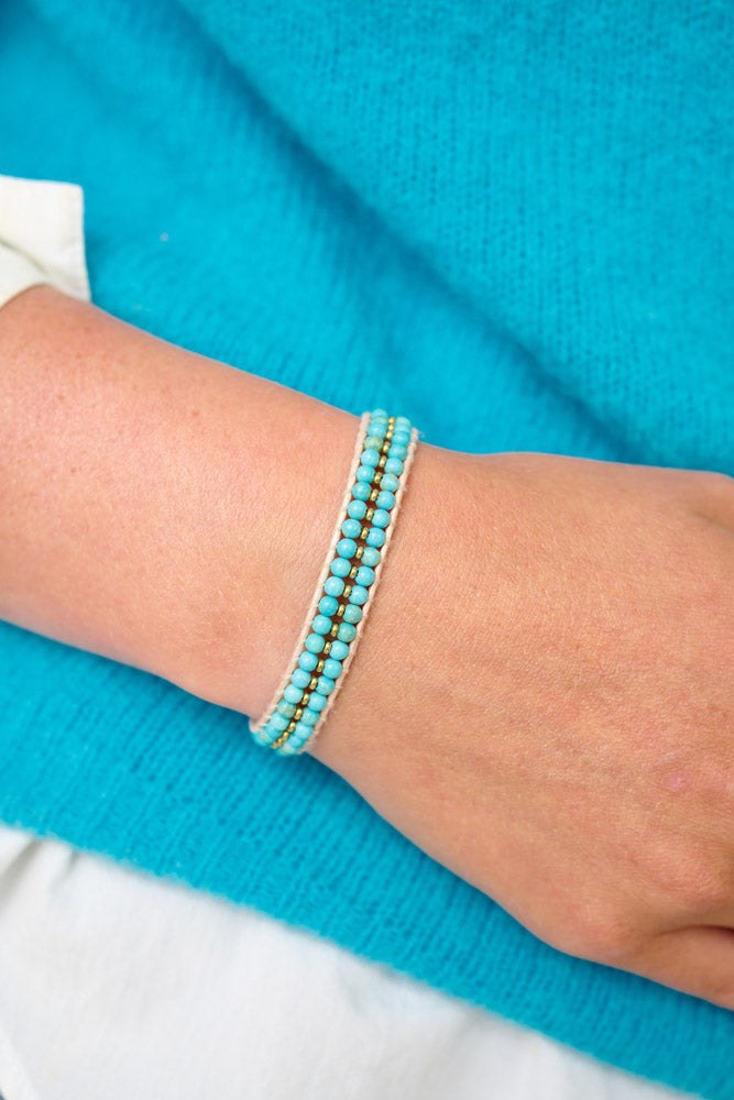 Lana Turquoise Gold Bracelet styled on the wrist, showing its woven gold and turquoise esign, ideal for spring or summer and beach lovers and travel-inspired fashion.